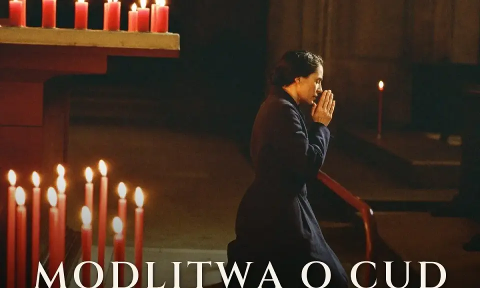 Kobieta klęczy w kościele, dłonie złożone do modlitwy. Płoną świece, tworząc atmosferę nadziei i modlitwy o cud.