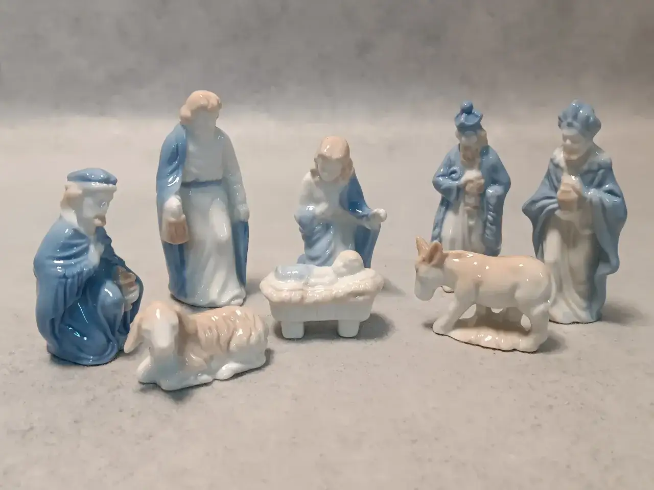 Figurki szopki bożonarodzeniowej: Maryja, J&oacute;zef, Dzieciątko Jezus w żł&oacute;bku, owieczka, osiołek i trzej kr&oacute;lowie. Narodził się nam zbawiciel tekst.