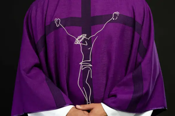 Fioletowa szata liturgiczna z haftowanym wizerunkiem Jezusa na krzyżu.