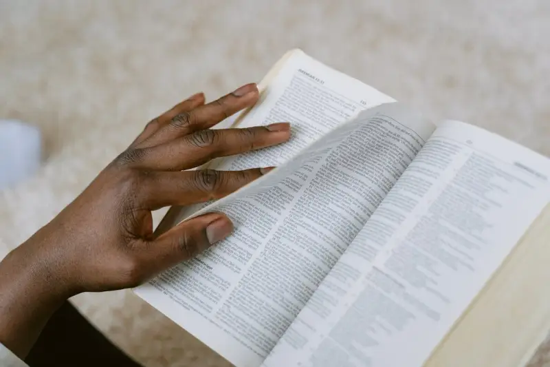 Dłoń przewracająca strony Biblii, szukająca pocieszenia w Psalmie 27.